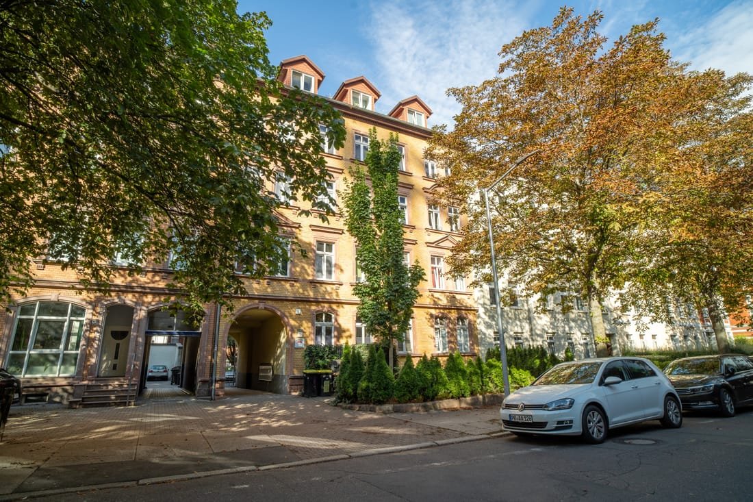 Straßenansicht des Altbaus mit Baumreihe davor